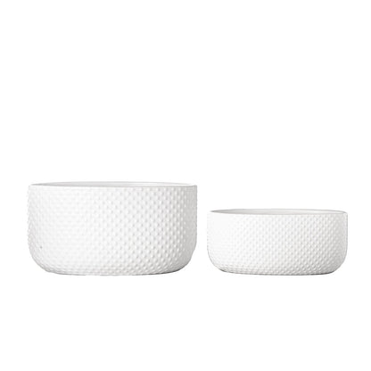 Two white textured ceramic bowls on a white background