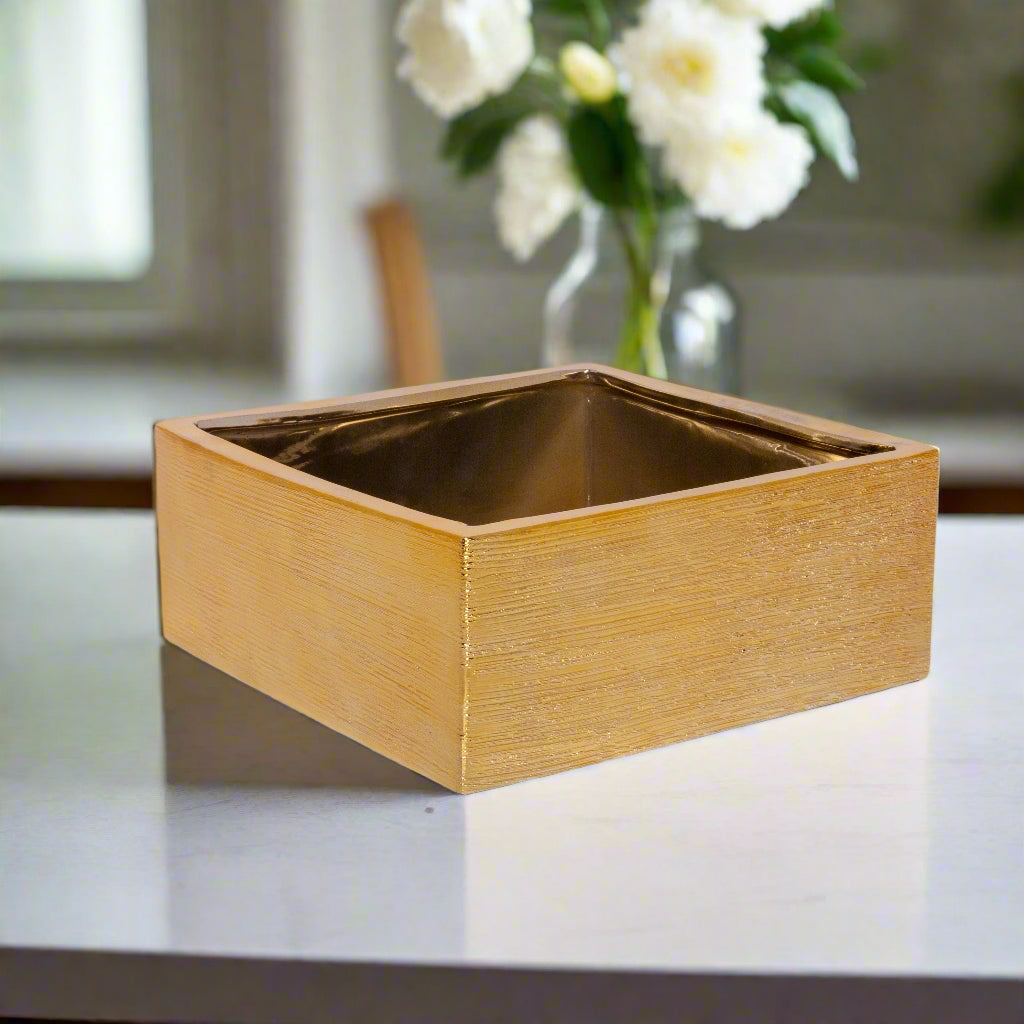 A ceramic square pot with a brushed gold design and a gloss finish.