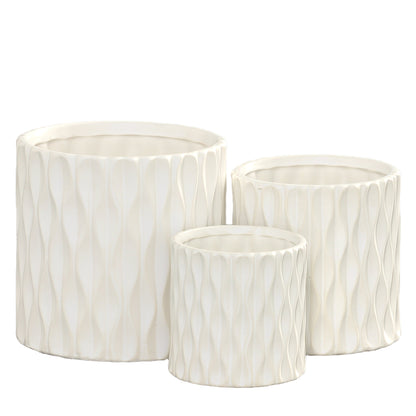 Set of three white ceramic cylindrical pots with embossed wave designs and matte finish.