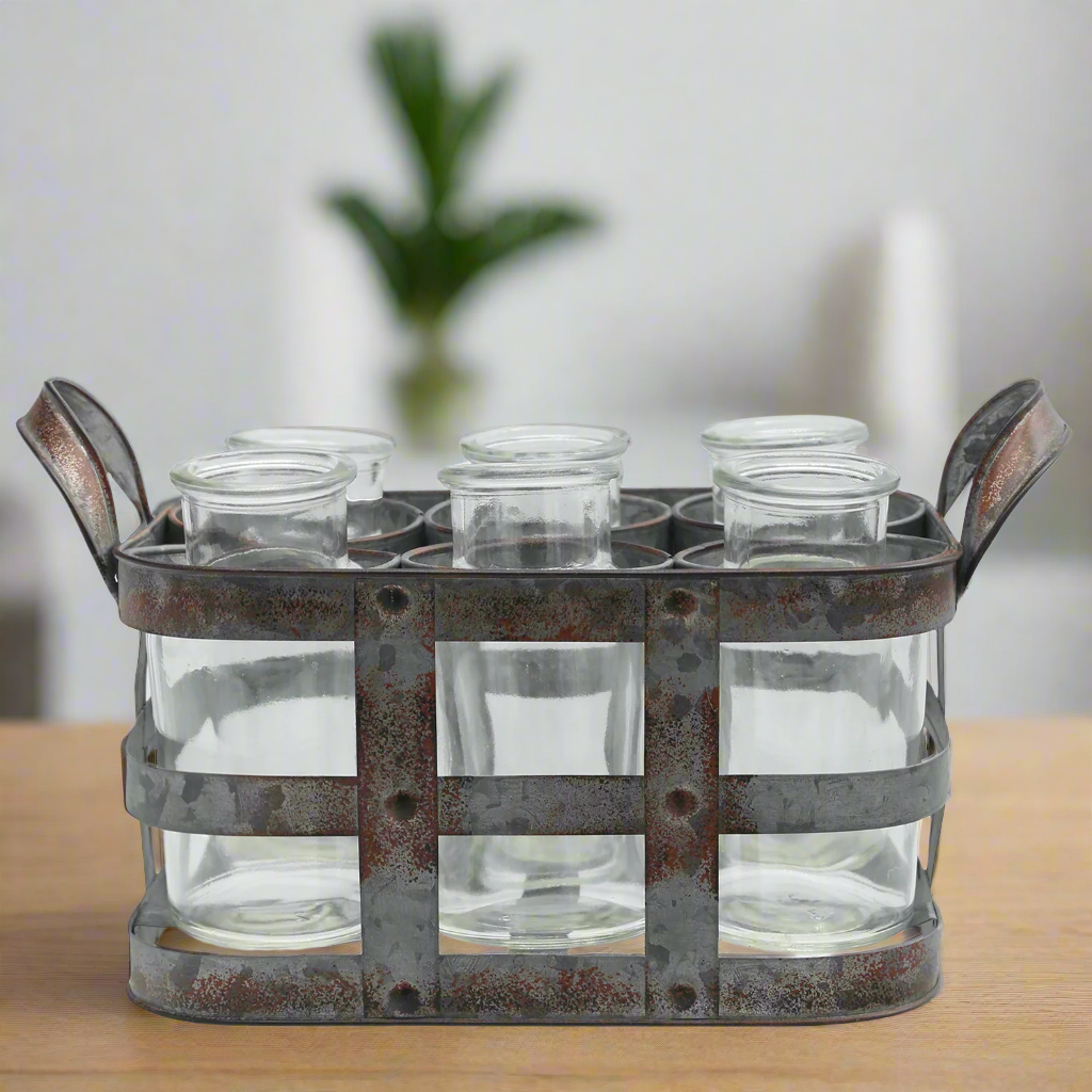 Metal holder with six clear glass jars on a wooden surface