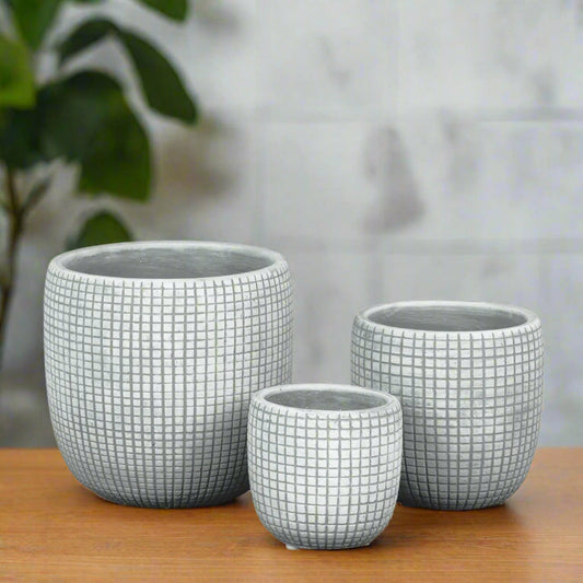 Three gray ceramic planters with grid pattern on a white background