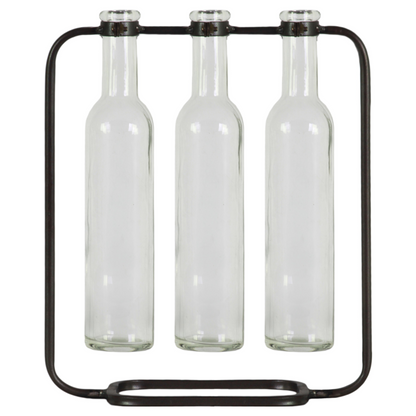 Three clear glass bottles held in place by a black metal stand on a white background